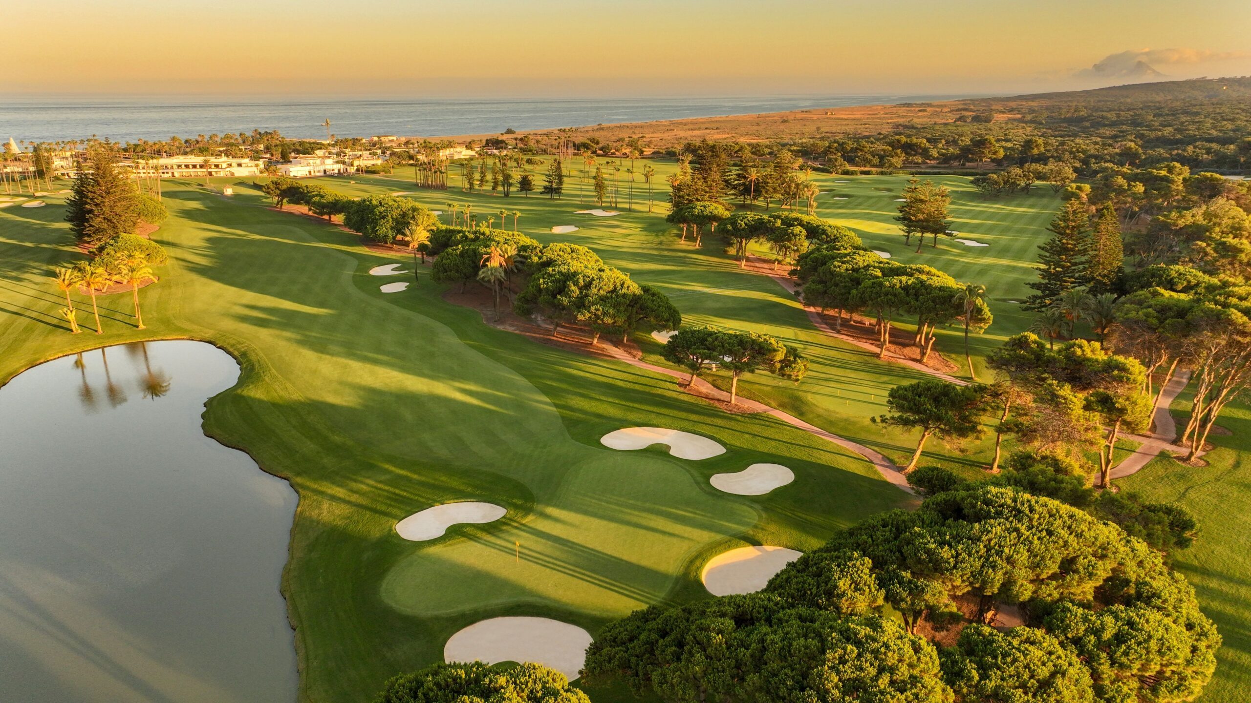 sotototot Aerial view of a golf course in Sotogrande with coastal scenery and Gibraltar in the background.