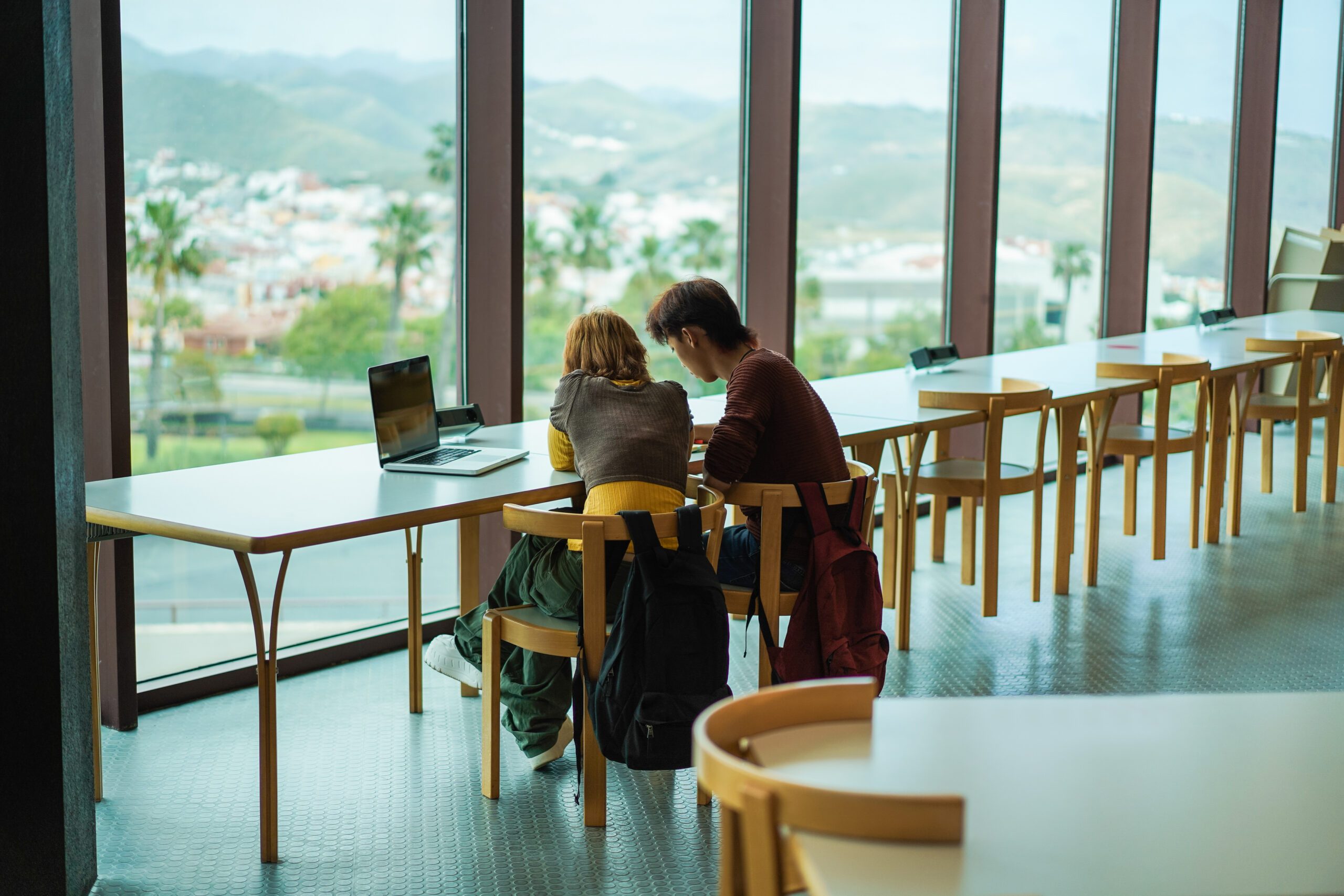 Young students studying inside university library - Focus on girl back